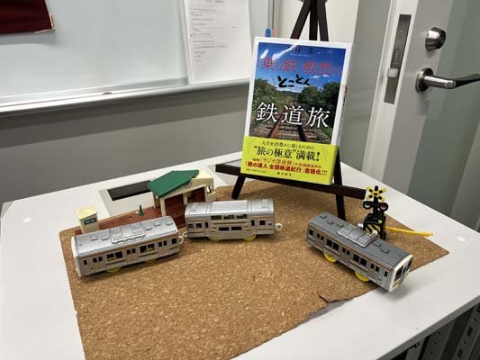 05_教室飾_宮村先生著書と電車模型.jpg