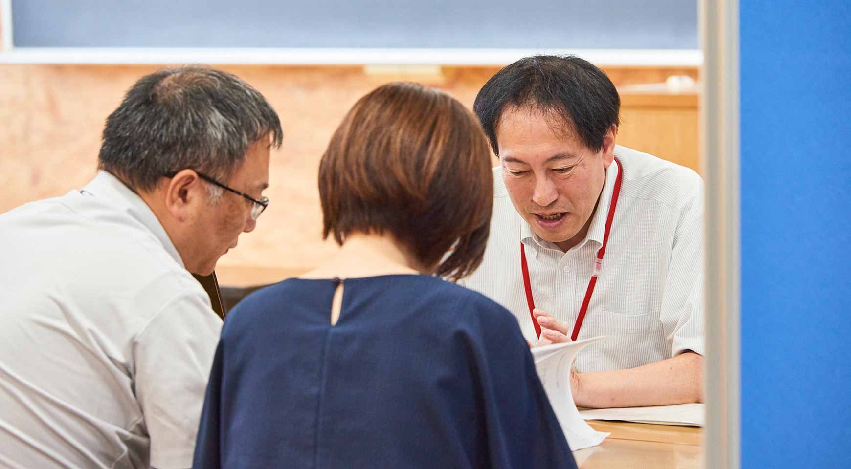 教員との個別面談で説明を受ける保護者