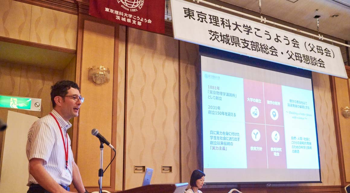 全体会でスクリーンを使って説明している様子