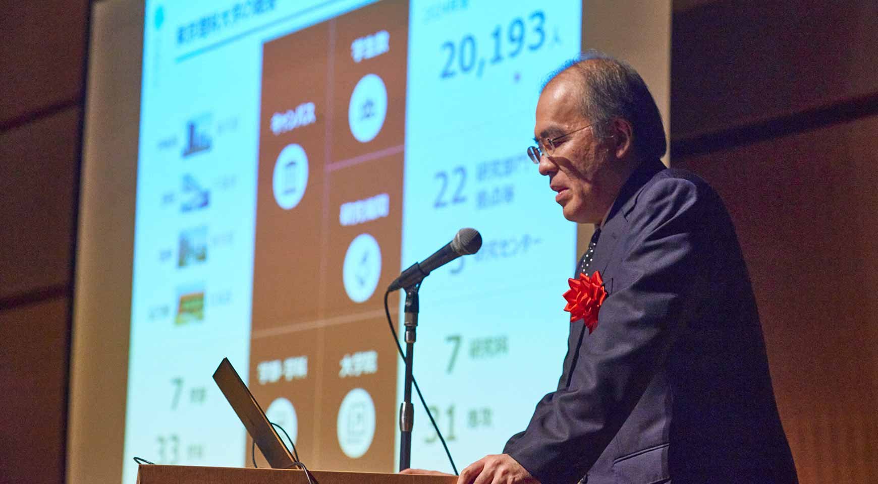 父母懇談会の受付で資料を受け取る参加者